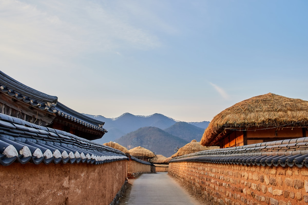 Traditional Korean walls and thatched-roof buildings lining a village path, Andong Hahoe Folk Village, South Korea