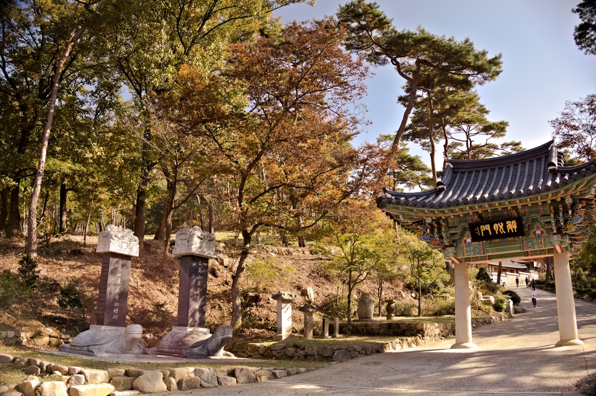 Korean temple gate with autumn trees and stone monuments, Andong area, South Korea