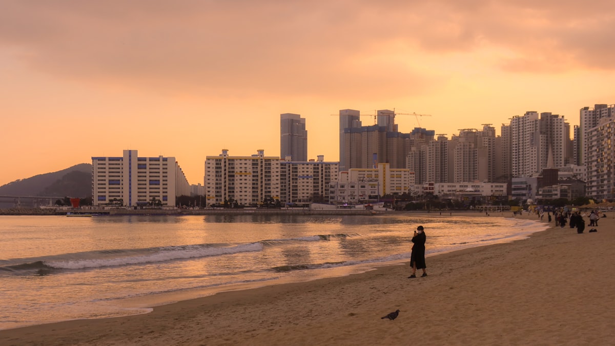 Busan beach at sunset with city skyline and high-rise buildings in the background