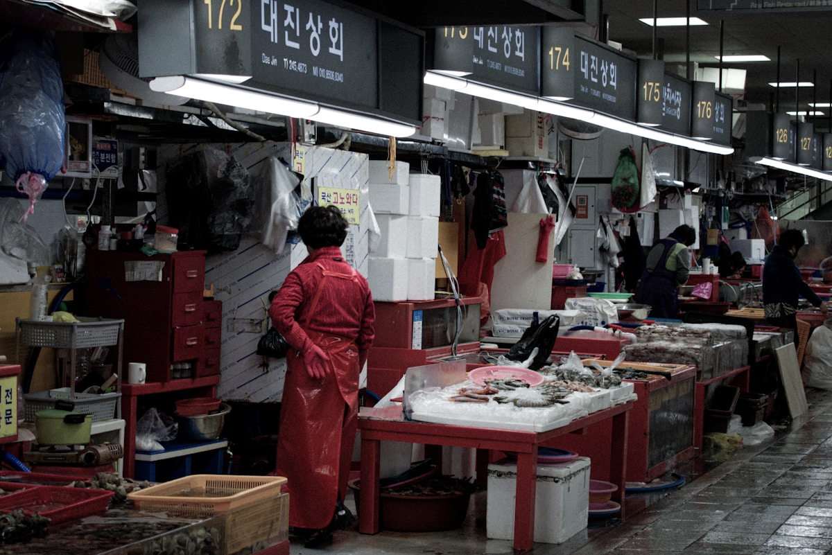 Vendor in red coverall at Jagalchi Fish Market in Busan, South Korea