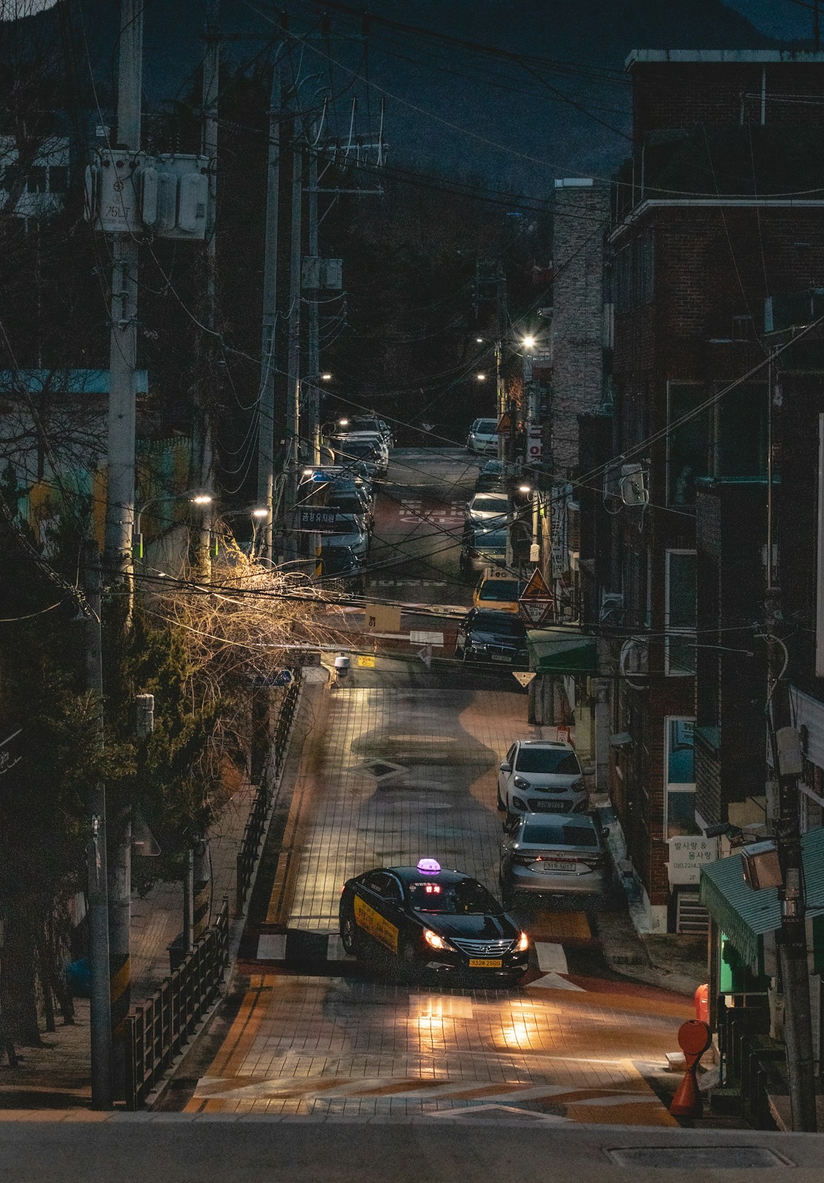 Daegu city street at night with a Korean taxi cab and lit buildings in the background
