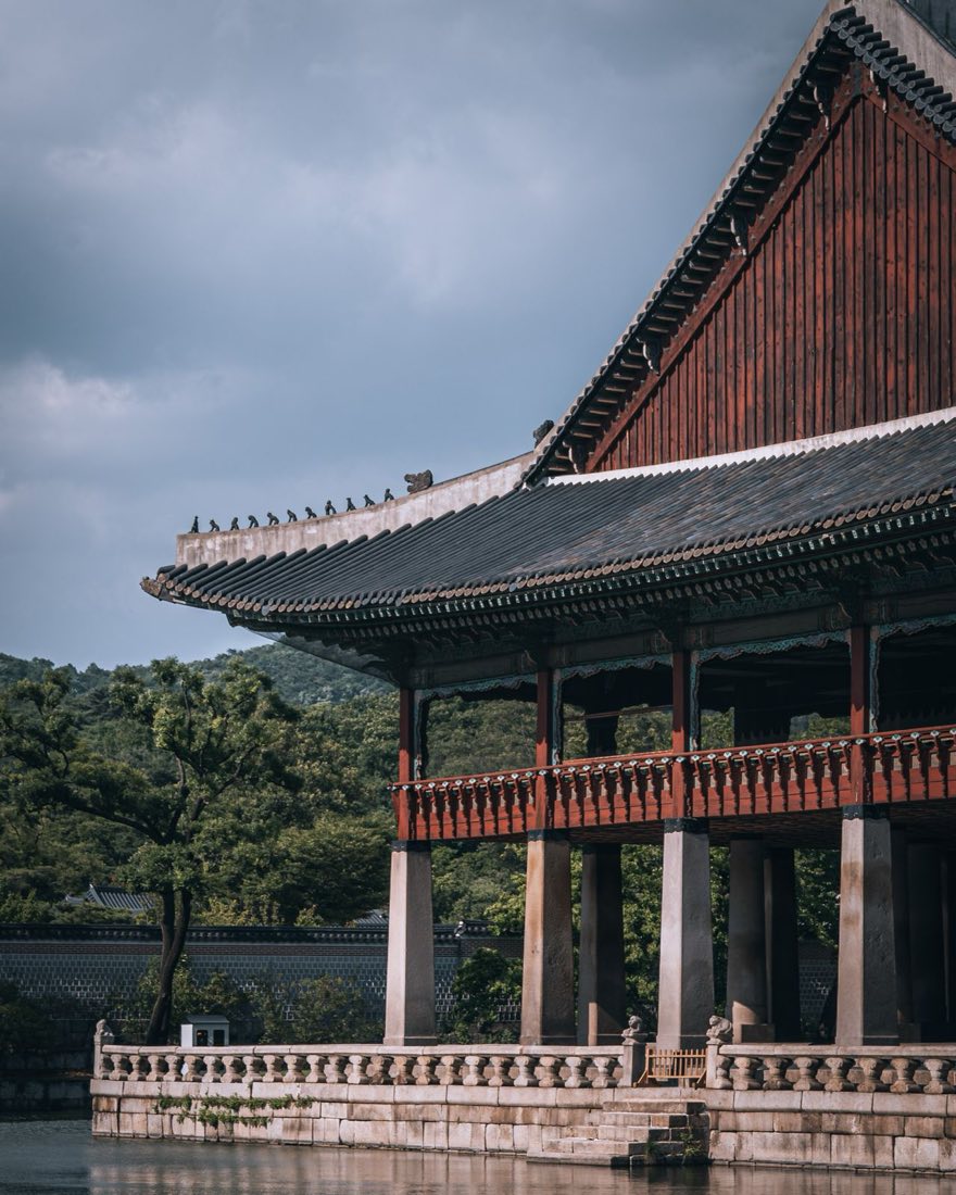 Seoul city panorama in autumn with golden and red tree canopy across Bukhansan hillsides and palace grounds