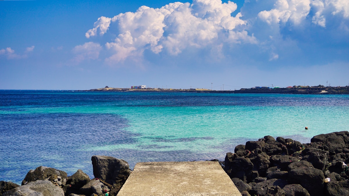 Turquoise sea and volcanic black rocks on the Jeju Island coast, South Korea
