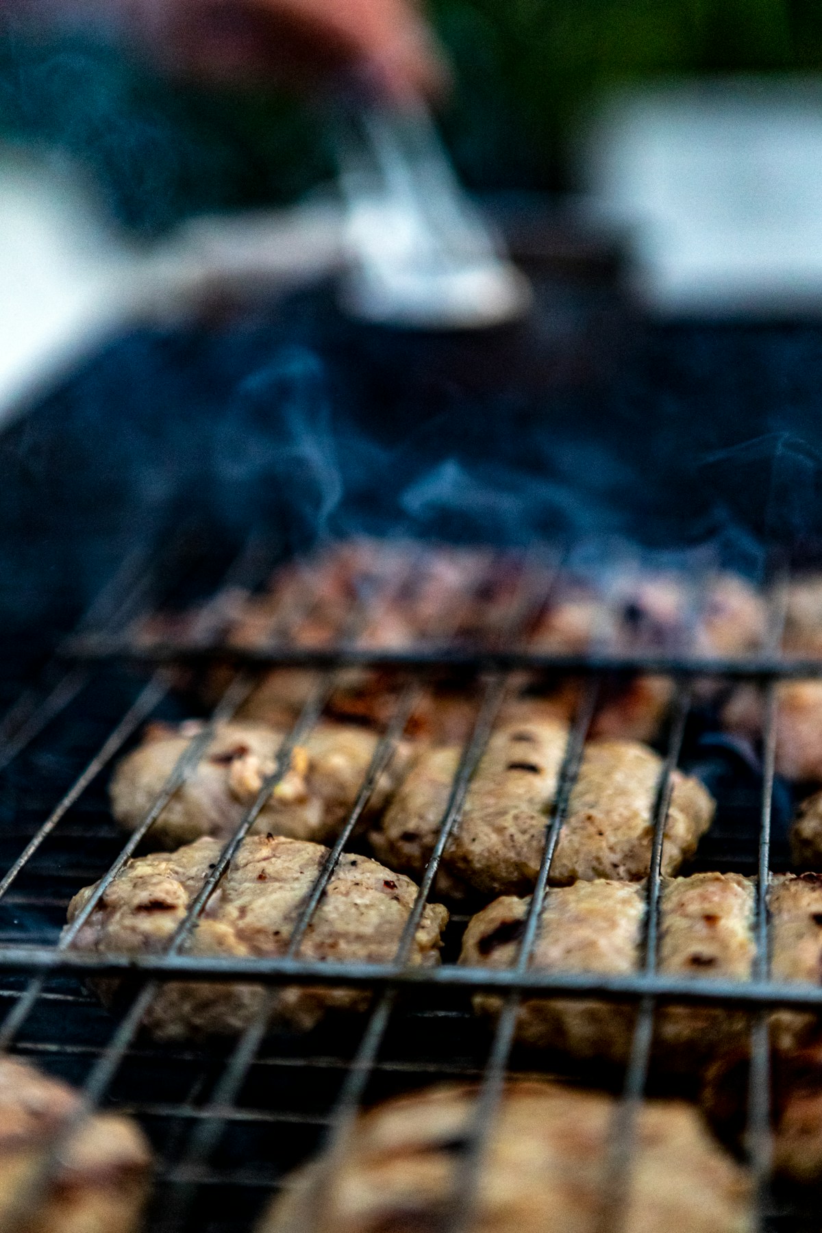 Grilled Jeju black pork heukdwaeji slices on charcoal grill with side dishes