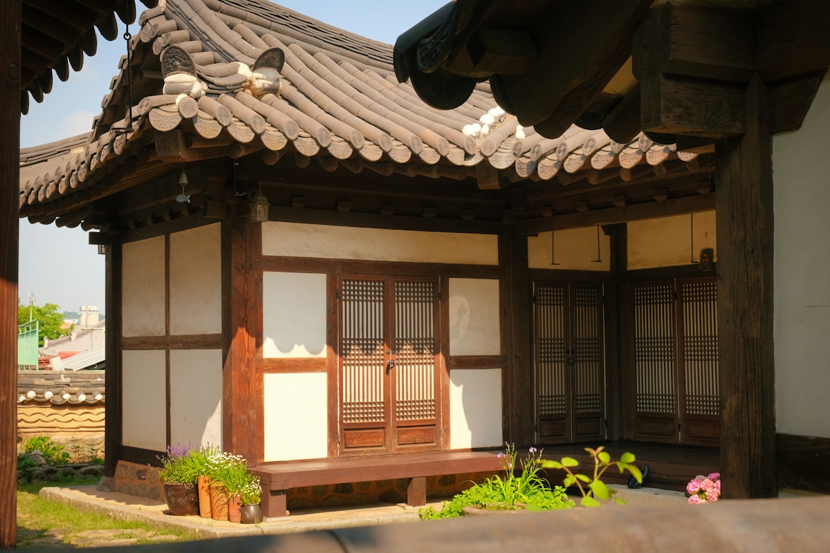 Traditional hanok building with wooden bench and flowers, Jeonju, South Korea