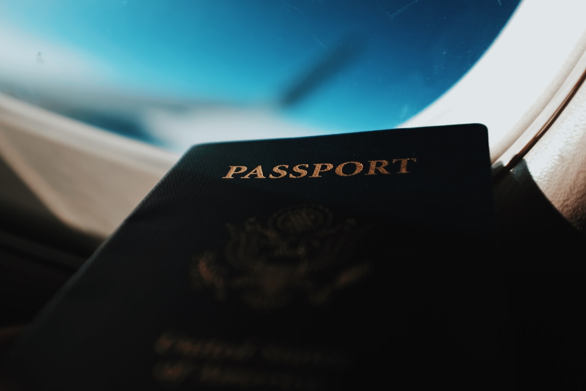 Passport booklet resting against an airplane window - K-ETA and visa guide for South Korea