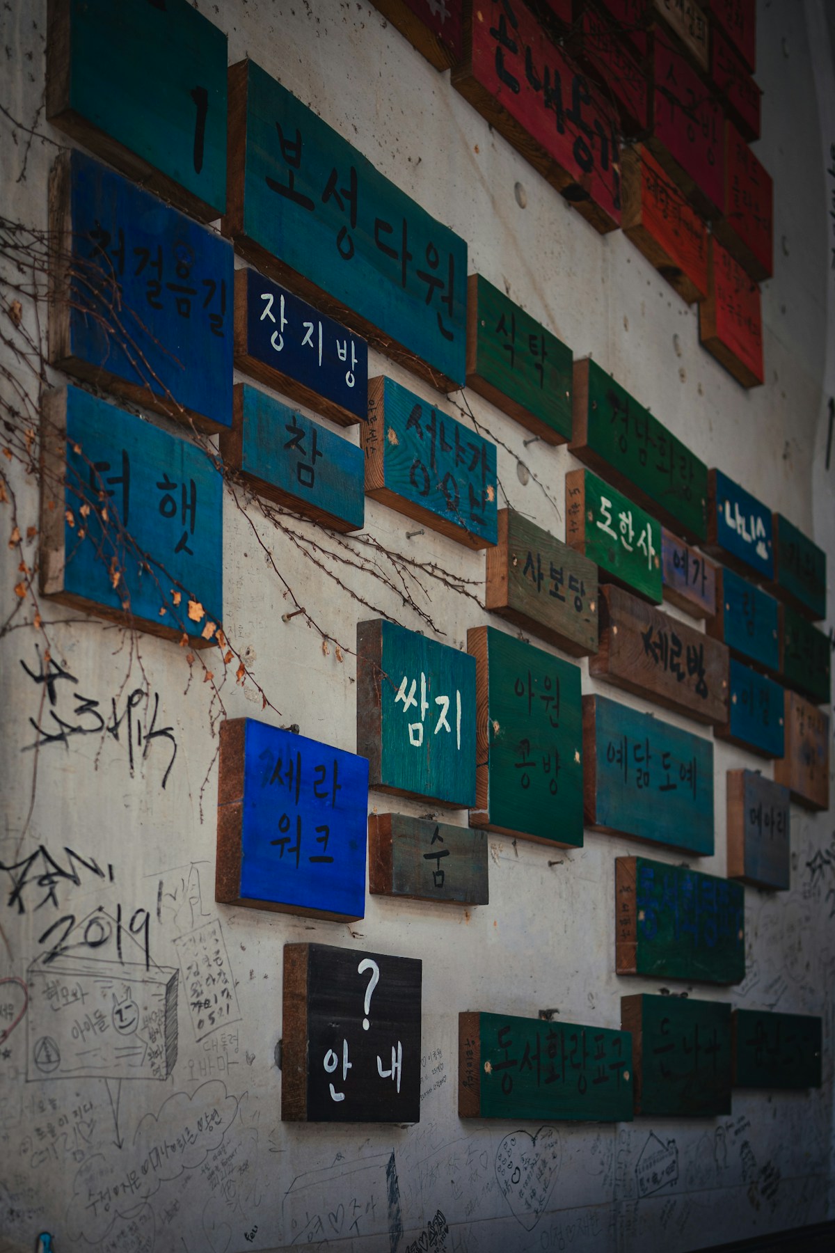 Colourful wooden signs covered in Korean Hangul characters mounted on a wall in Seoul