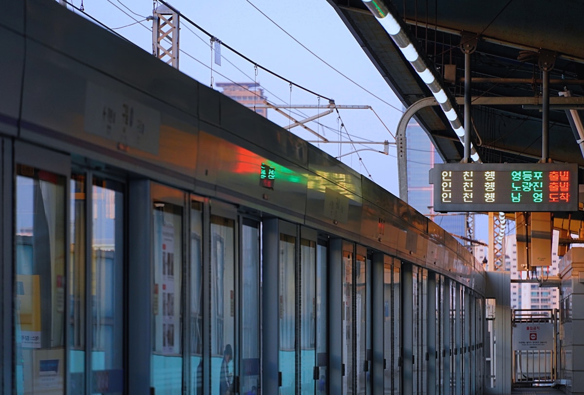 Korean metro train at a Seoul station platform with Hangul departure boards showing Incheon-bound services
