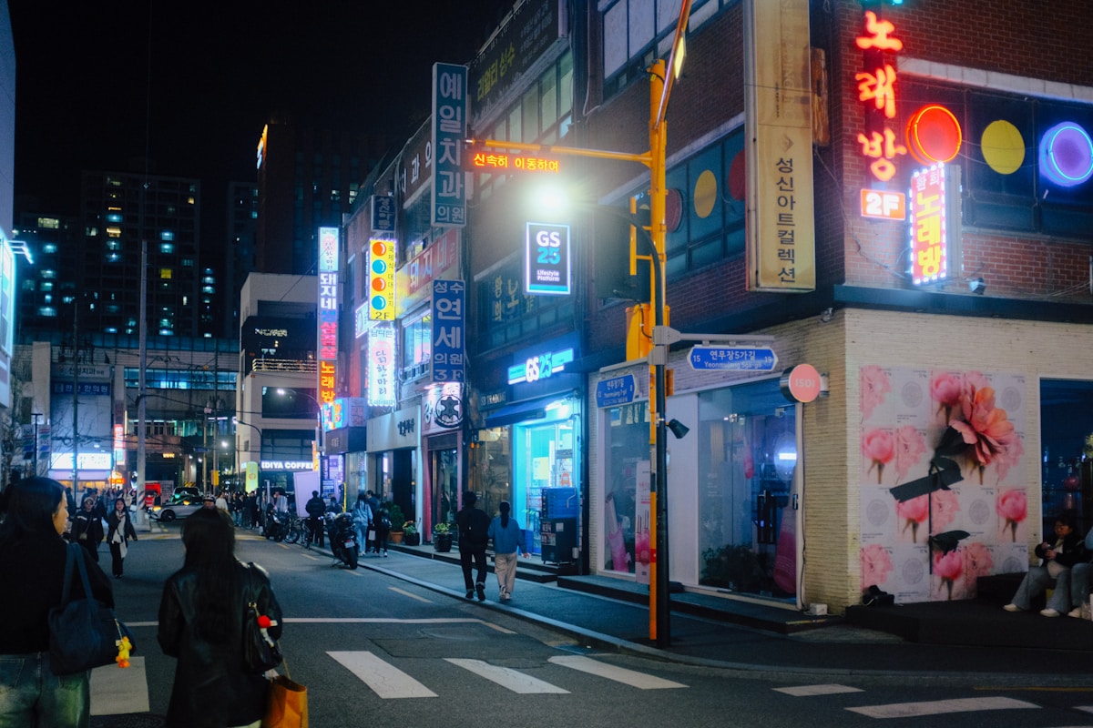 Neon-lit Seoul street at night with Korean signs and crowds outside bars
