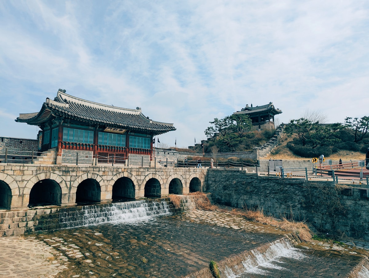 Hwahongmun water gate at Hwaseong Fortress with flowing water and traditional Korean architecture, Suwon, South Korea
